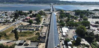 El Ministerio de Obras Públicas (MOP) de la Región del Biobío, por medio de la dirección de Vialidad, informó acerca de los avances en el proceso de asfaltado de la superestructura, también de la instalación de barreras laterales de hormigón, entre otros aspectos. Así lo confirmó el seremi de Obras Públicas, Hugo Cautivo, quien expresó que “estamos ya entrando en una etapa final de lo que es el viaducto Chacabuco, con los trabajos de asfaltado de la superficie de rodado, que en poco tiempo más permitirá transitar por este lugar”. “En este minuto estamos terminando lo que son las pavimentaciones, lo que son los muros aledaños. Esperamos que durante los primeros días de marzo esto ya esté terminado en lo que es el área de trabajo del viaducto Chacabuco”, dijo Cautivo. La obra, que ya cuenta con la instalación completa de sus vigas estructurales, tiene como prioridad enfocarse en los acabados finales, como las aceras de hormigón y ciclovías. Por otro lado, en el nuevo anfiteatro de San Pedro de la Paz se progresa con las gradas, en un espacio que permitirá la realización de actividades culturales, recreativas, y que va a implicar de alguna forma un aporte al desarrollo”, destacó la autoridad del MOP. Respecto de los plazos, Cautivo adelantó que “tuvimos que realizar una modificación del convenio de este contrato por el cambio de normativa en materia de iluminación, lo que también significó un cambio de diseño. Ya con esas autorizaciones vamos a empezar recién con la ejecución de obra de todo lo que es el proyecto de iluminación a partir de marzo de este año y por lo mismo la fecha de término, desde el punto de vista contractual se proyecta para junio de este año”. Se estima que el viaducto esté finalizado en junio del 2026, con el objetivo de aportar notoriamente a la reducción de tiempos de viaje y la descongestión vial en la comuna de San Pedro de la Paz y la conexión con Concepción.